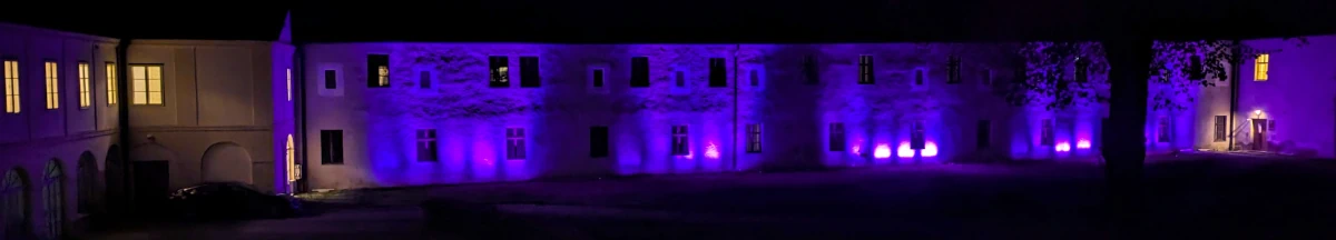 Eine Seite des Schlossinnenhofs mit bunten Lichtern beleuchtet